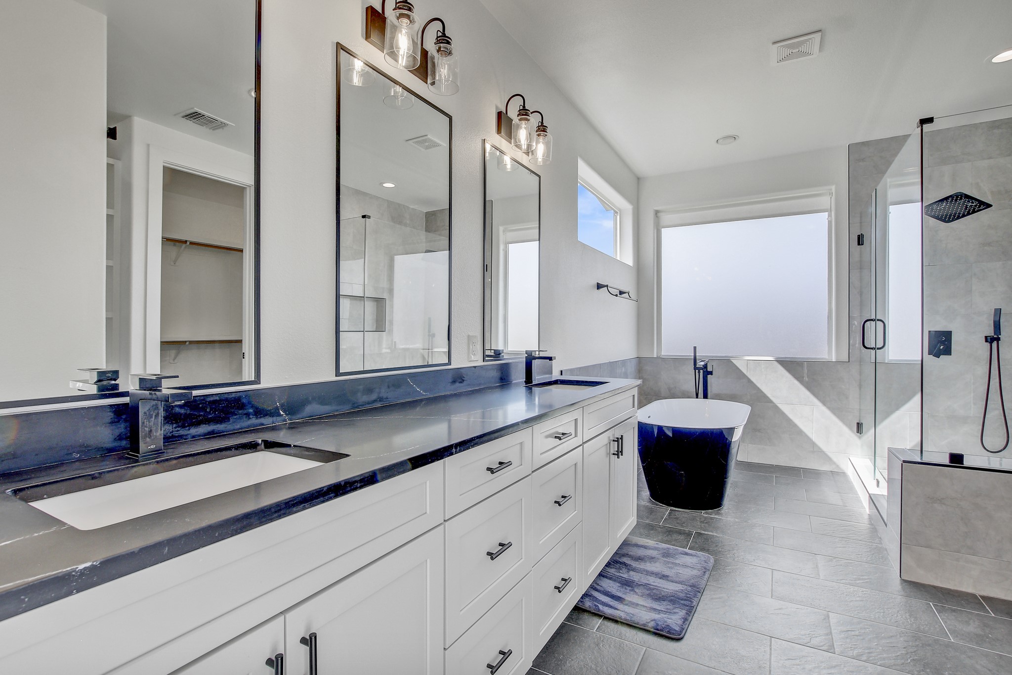 4703 Louis Avenue, Unit A Austin, TX 78721 - Photo 21 of 35 Full bathroom featuring a shower stall, tile walls, double vanity, light tile patterned floors, and a freestanding tub