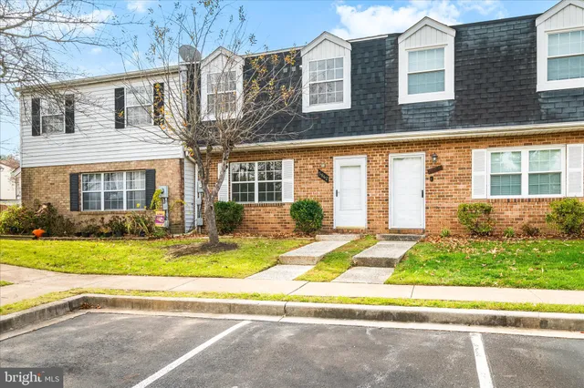 a view of a brick house with many windows next to a road