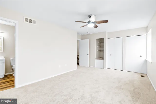 a view of an empty room with a ceiling fan