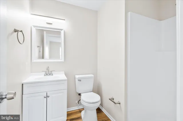 a bathroom with a toilet sink vanity and mirror