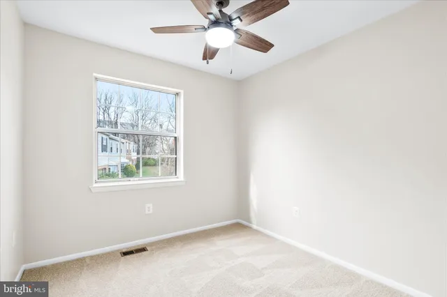 an empty room with a window and a fan