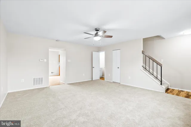 an empty room with fan and windows