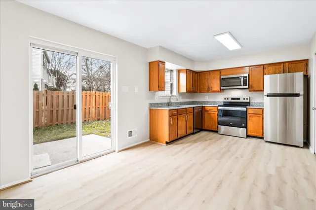 a kitchen with stainless steel appliances granite countertop a stove top oven and a refrigerator