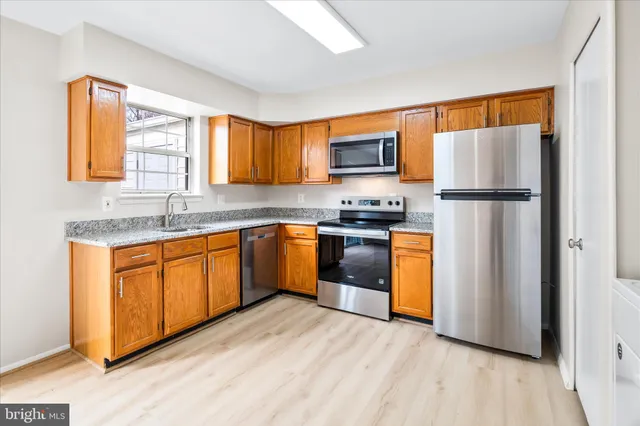 a kitchen with stainless steel appliances granite countertop a refrigerator sink and microwave