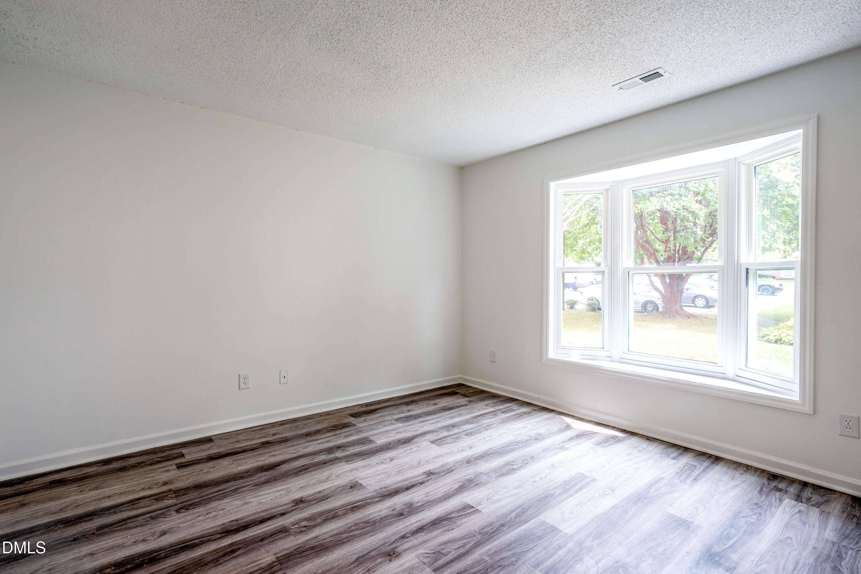 6901 Saxby Court Raleigh, NC 27613 - Photo 27 of 36 an empty room with wooden floor and windows