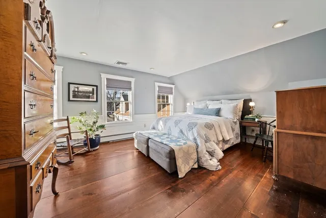 a view of a hallway with wooden floor and entryway