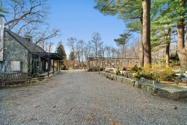 a view of a street with chairs and a tree