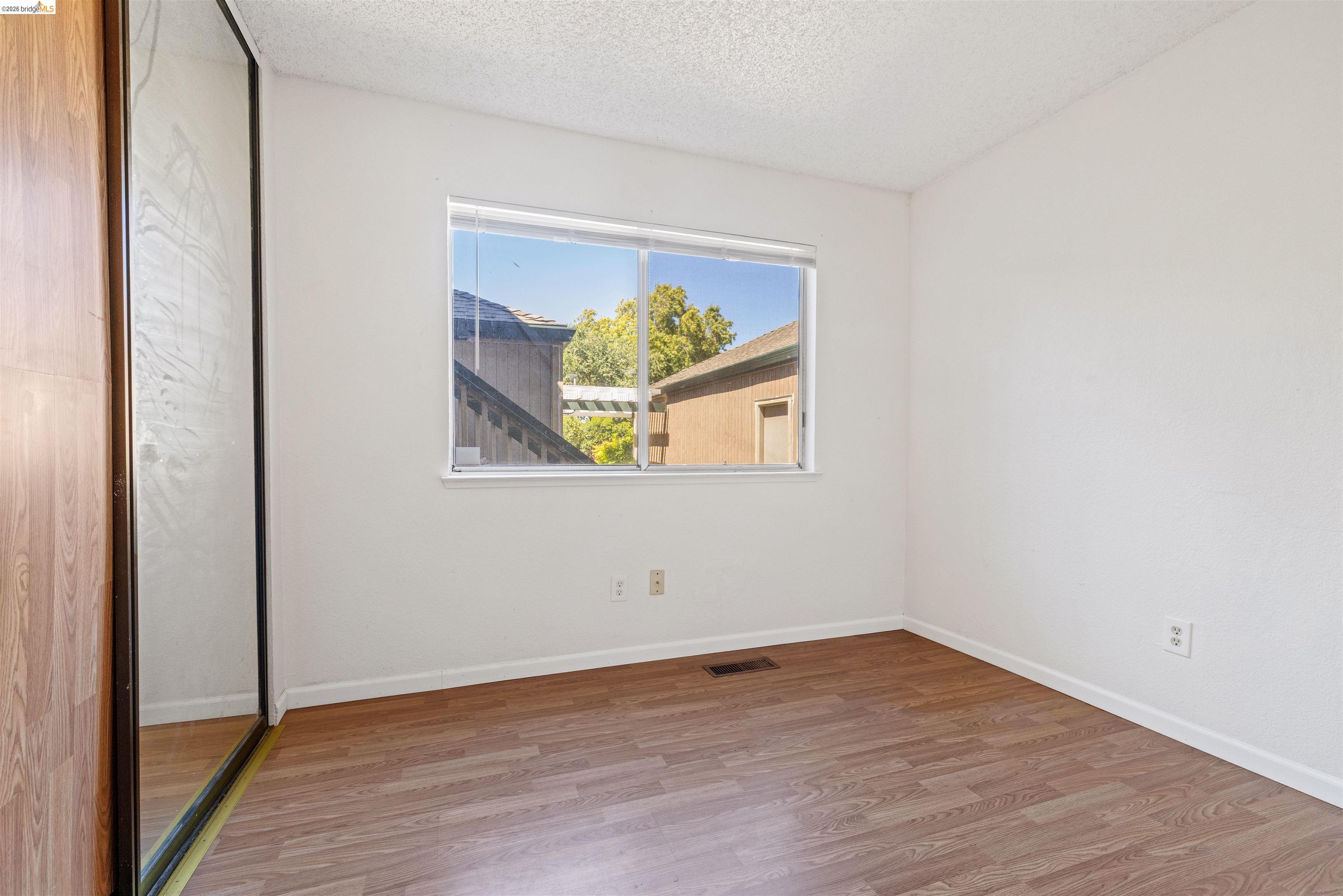 1151 Chadwick Circle Bay Point, CA 94565 - Photo 10 of 23 Bedroom featuring wood-finish flooring, white walls, and a window with blinds