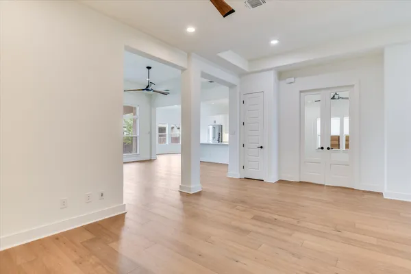 an empty room with windows and fan