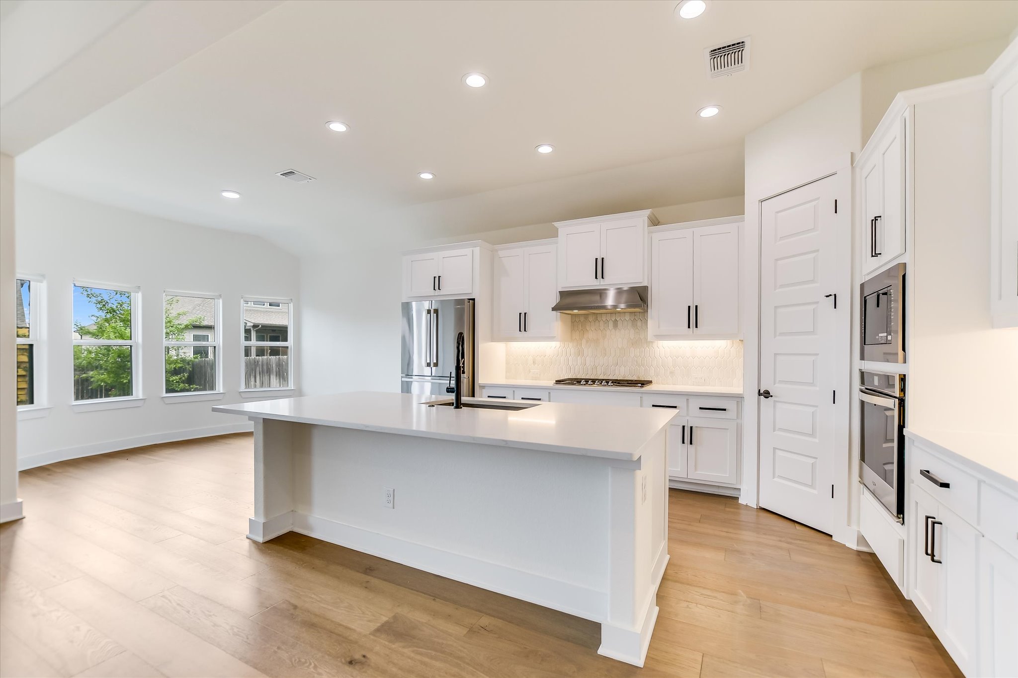 4300 Allenbrook Drive Pflugerville, TX 78660 - Photo 5 of 40 a large kitchen with stainless steel appliances granite countertop a large counter top and a stove top oven