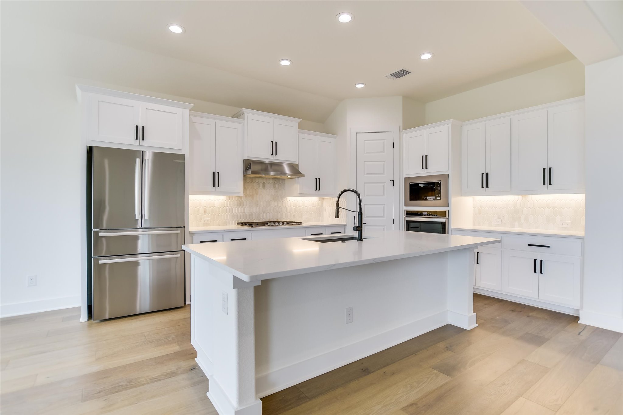 4300 Allenbrook Drive Pflugerville, TX 78660 - Photo 6 of 40 a kitchen with white cabinets and stainless steel appliances