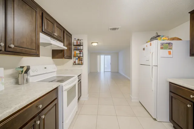 a kitchen with a sink a stove a refrigerator and cabinets