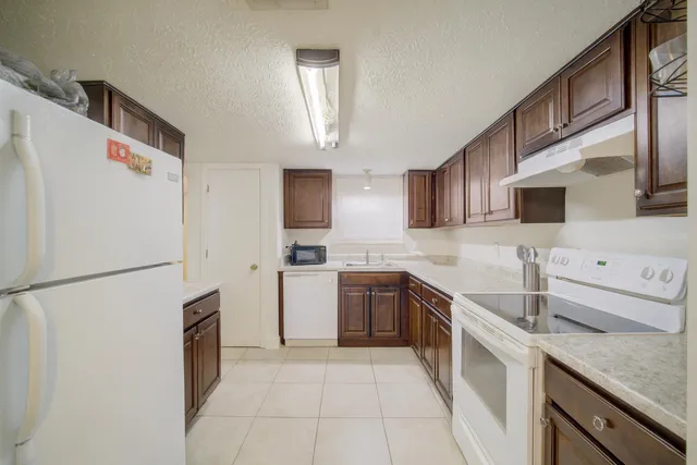 a kitchen with stainless steel appliances granite countertop a refrigerator sink stove and microwave