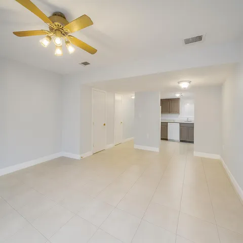 a view of an empty room with a kitchen