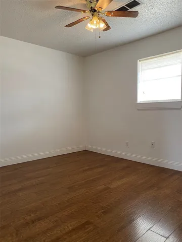 an empty room with wooden floor & closet area