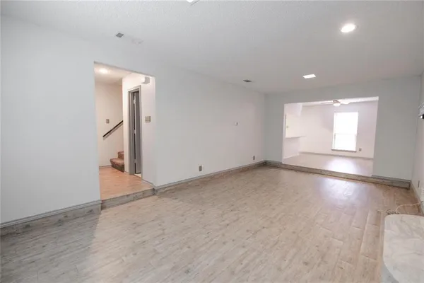 an empty room with a fireplace and wooden floor