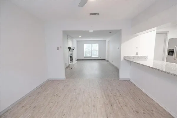 a kitchen with stainless steel appliances a sink a stove a refrigerator cabinets and a window