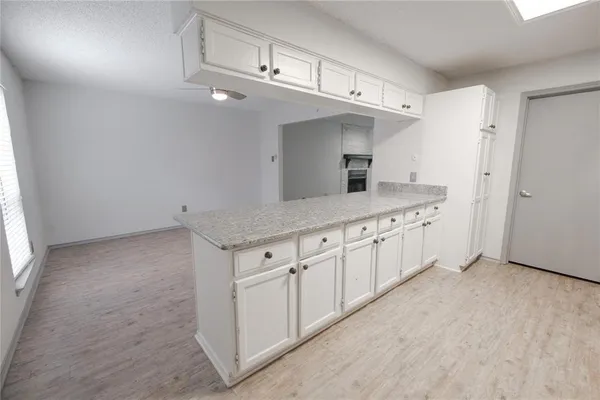 a kitchen with stainless steel appliances granite countertop a sink a stove a refrigerator and white cabinets