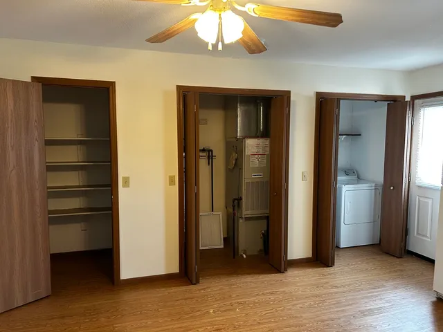 a view of an empty room with closet and a window