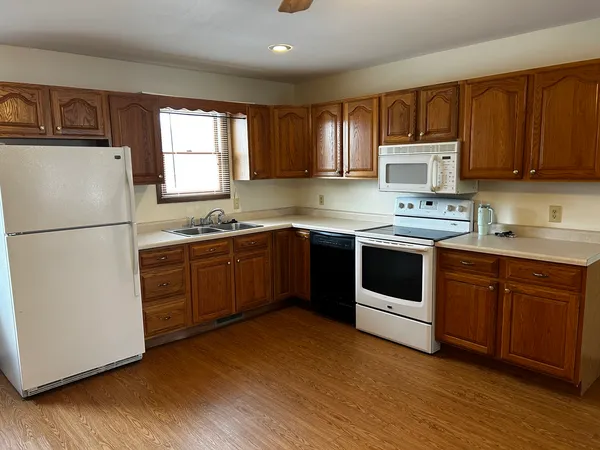 a kitchen with a white stove top oven and refrigerator