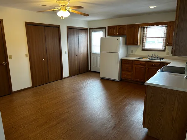 a kitchen with kitchen island wooden floors appliances and window