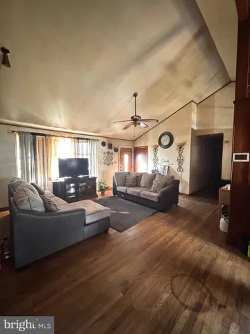 a living room with furniture a ceiling fan and a window