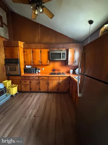 a kitchen with stainless steel appliances kitchen island granite countertop a sink and cabinets