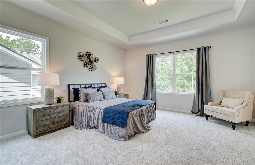 31 Butternut Way Auburn, GA 30011 - Photo 20 of 35 a spacious bedroom with a bed a couch and a window