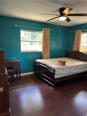 a bedroom with a bed and wooden floor