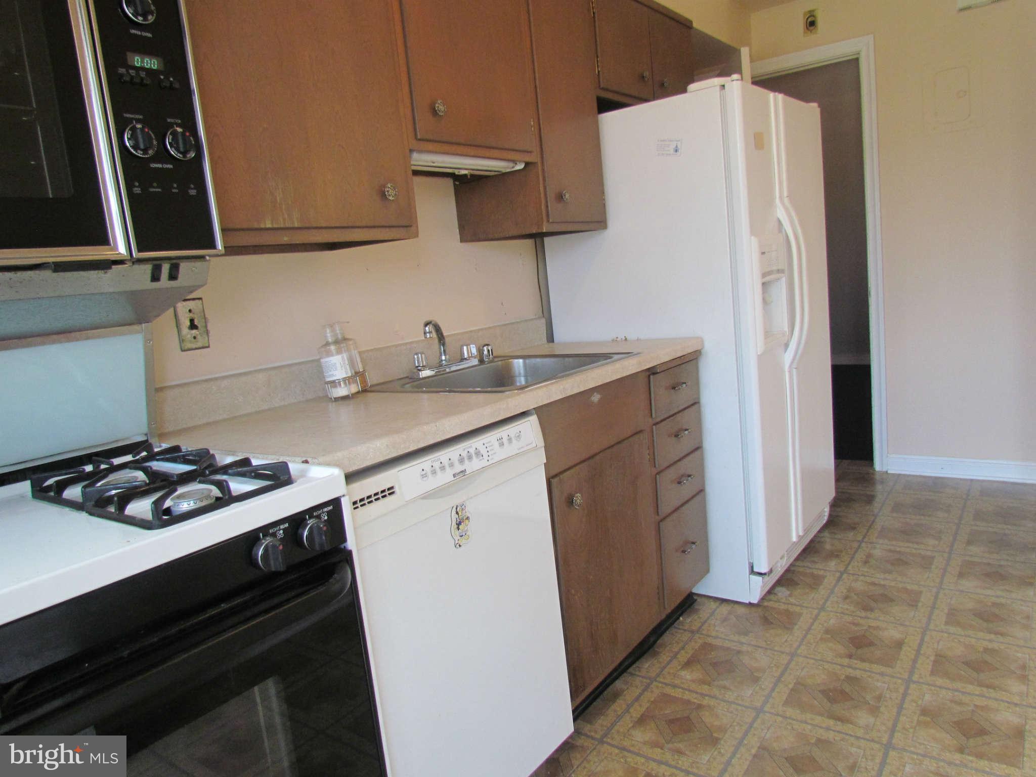 1327 Silverthorne Road Baltimore, MD 21239 - Photo 5 of 16 a kitchen with sink cabinets and stove