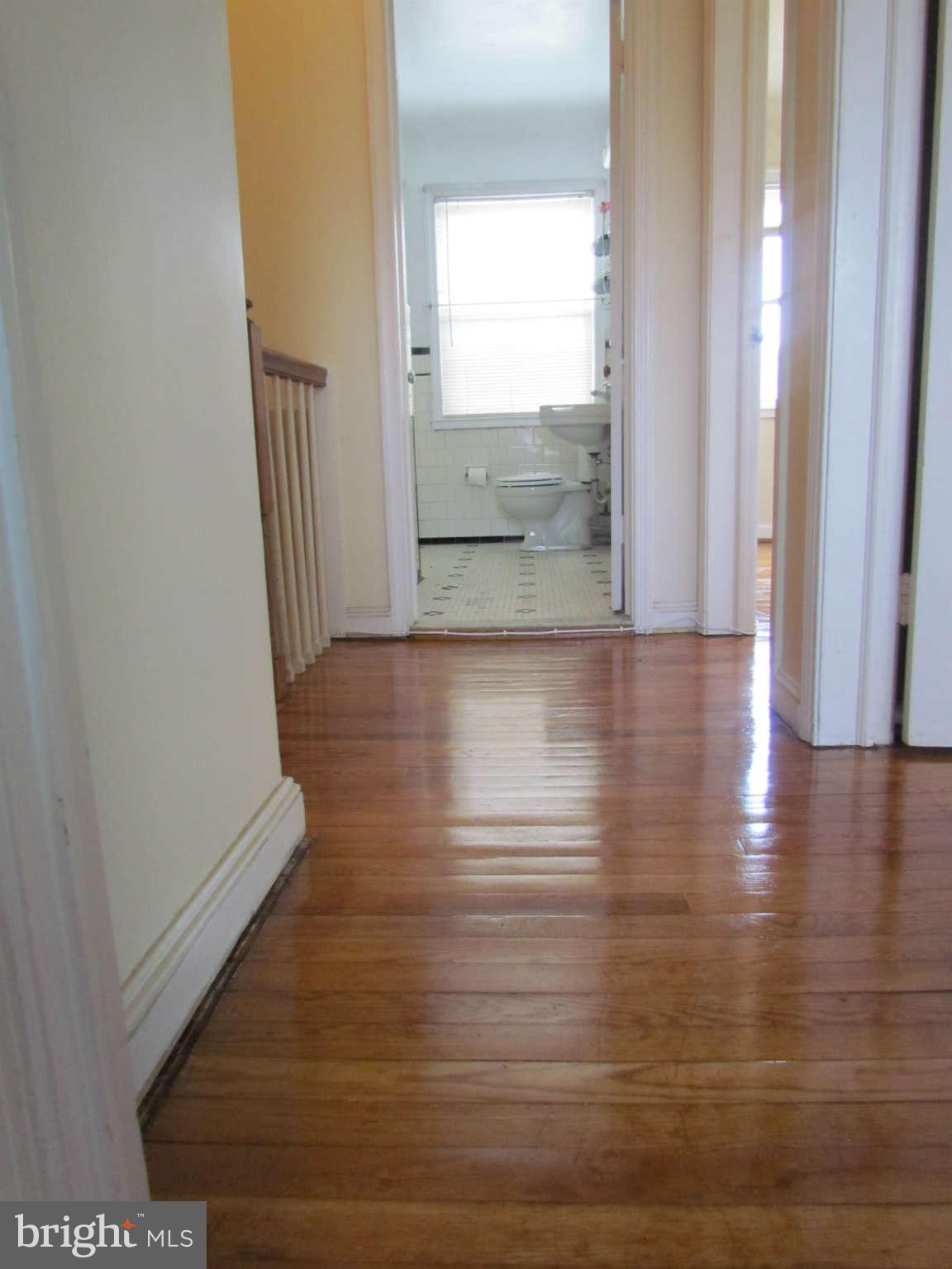 1327 Silverthorne Road Baltimore, MD 21239 - Photo 8 of 16 a view of a hallway view with wooden floor and staircase