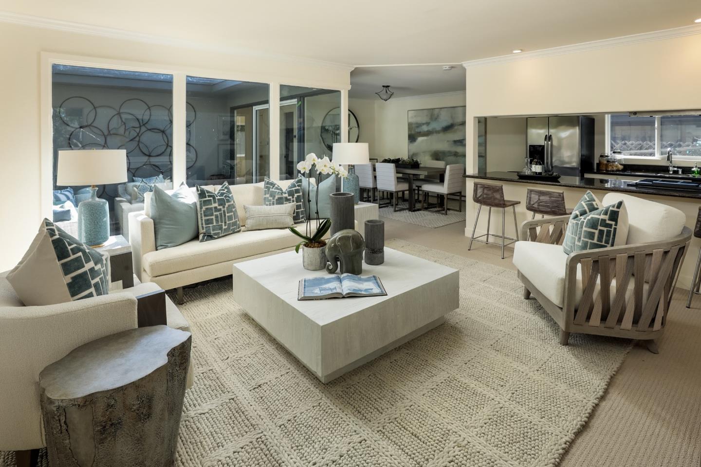 a living room with furniture and a view of kitchen