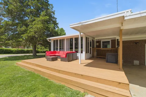 a view of a house with a backyard and sitting area