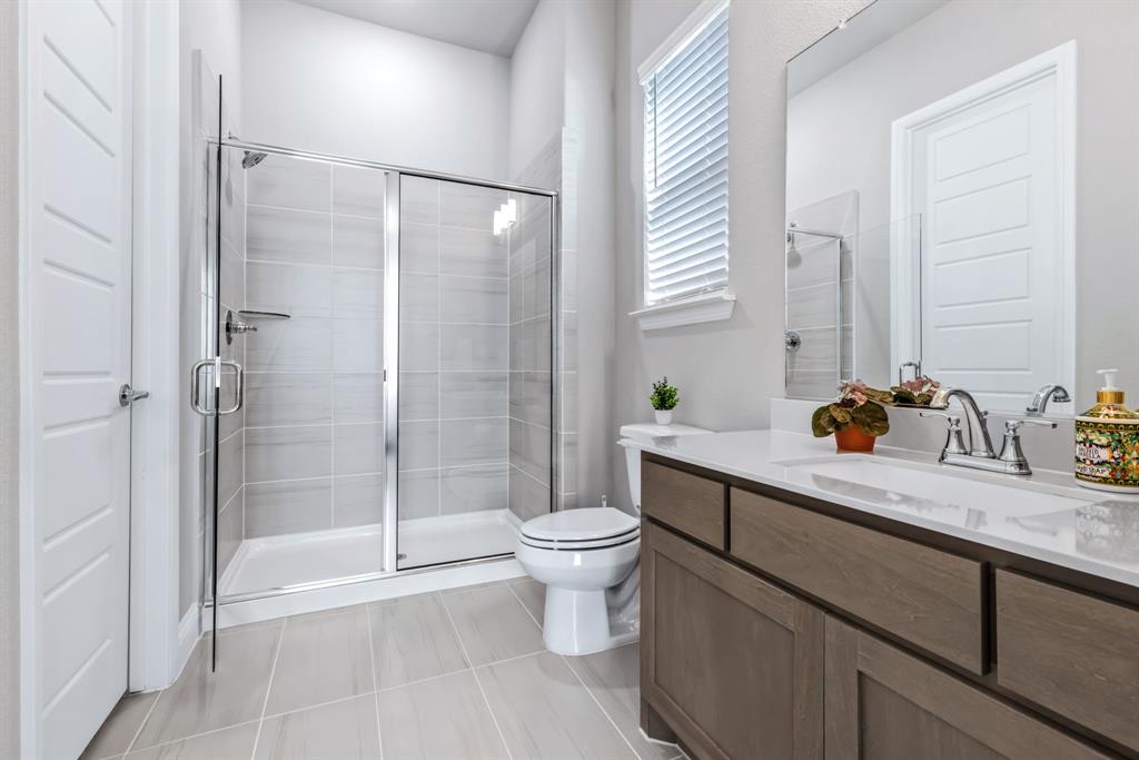 1302 Shorefront Drive Allen, TX 75013 - Photo 18 of 40 a bathroom with a granite countertop sink a toilet and shower