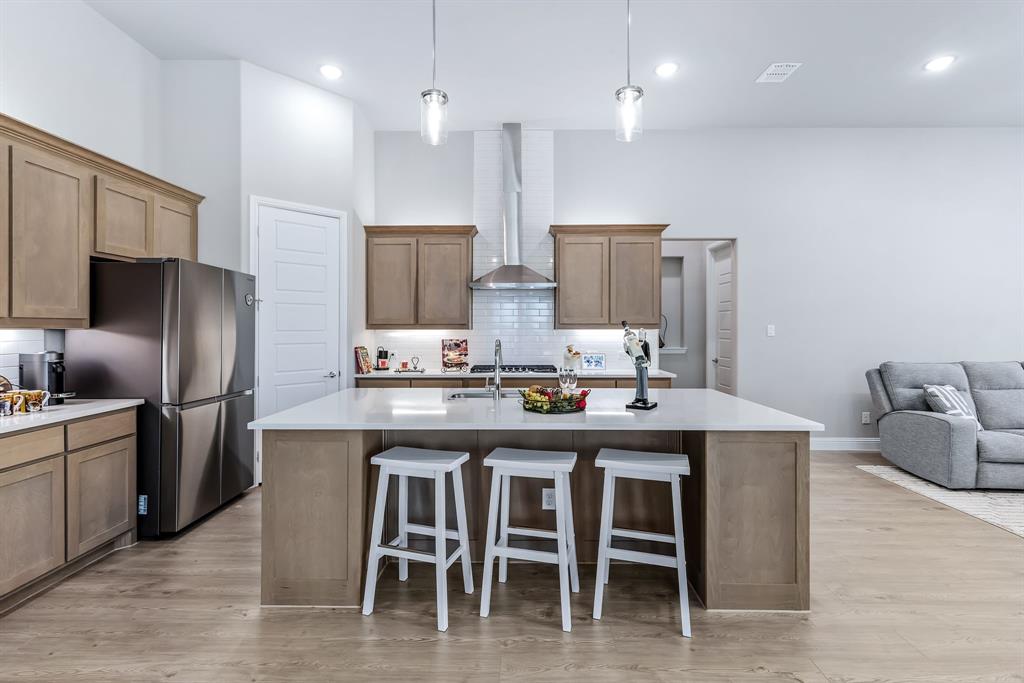 1302 Shorefront Drive Allen, TX 75013 - Photo 6 of 40 a kitchen with stainless steel appliances granite countertop a table chairs sink refrigerator and microwave