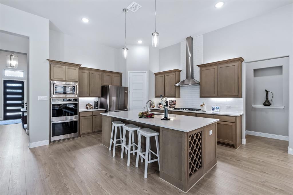 1302 Shorefront Drive Allen, TX 75013 - Photo 7 of 40 a kitchen with kitchen island granite countertop a sink stove and refrigerator