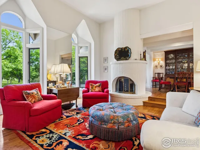 a living room with furniture a fireplace and a floor to ceiling window