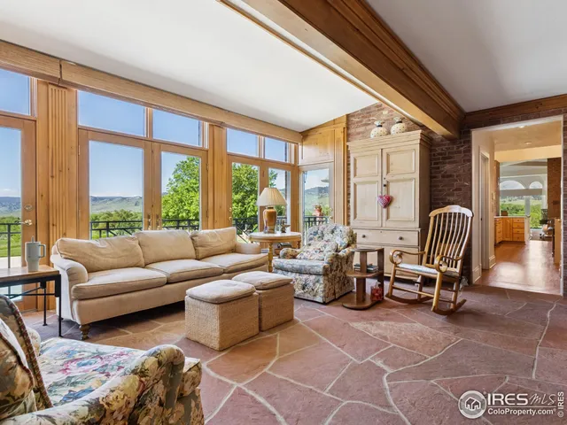 a living room with furniture and floor to ceiling windows