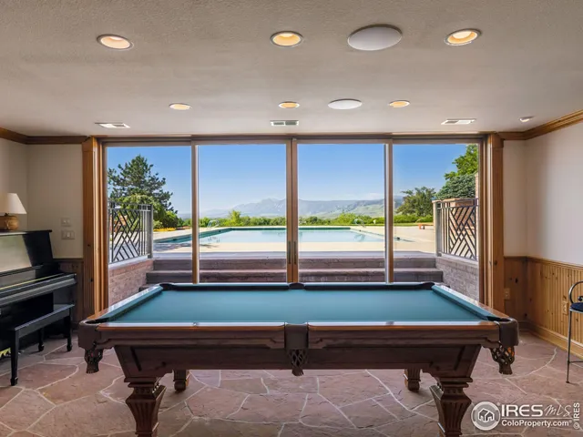 a room with pool table and windows