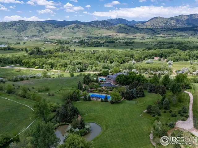 an aerial view of green landscape with trees houses and mountain view