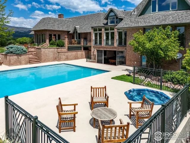 a view of house with swimming pool and outdoor seating