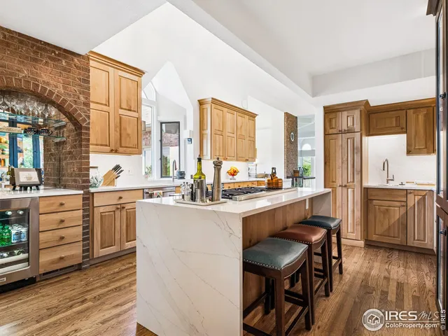 a kitchen with sink a stove and chairs