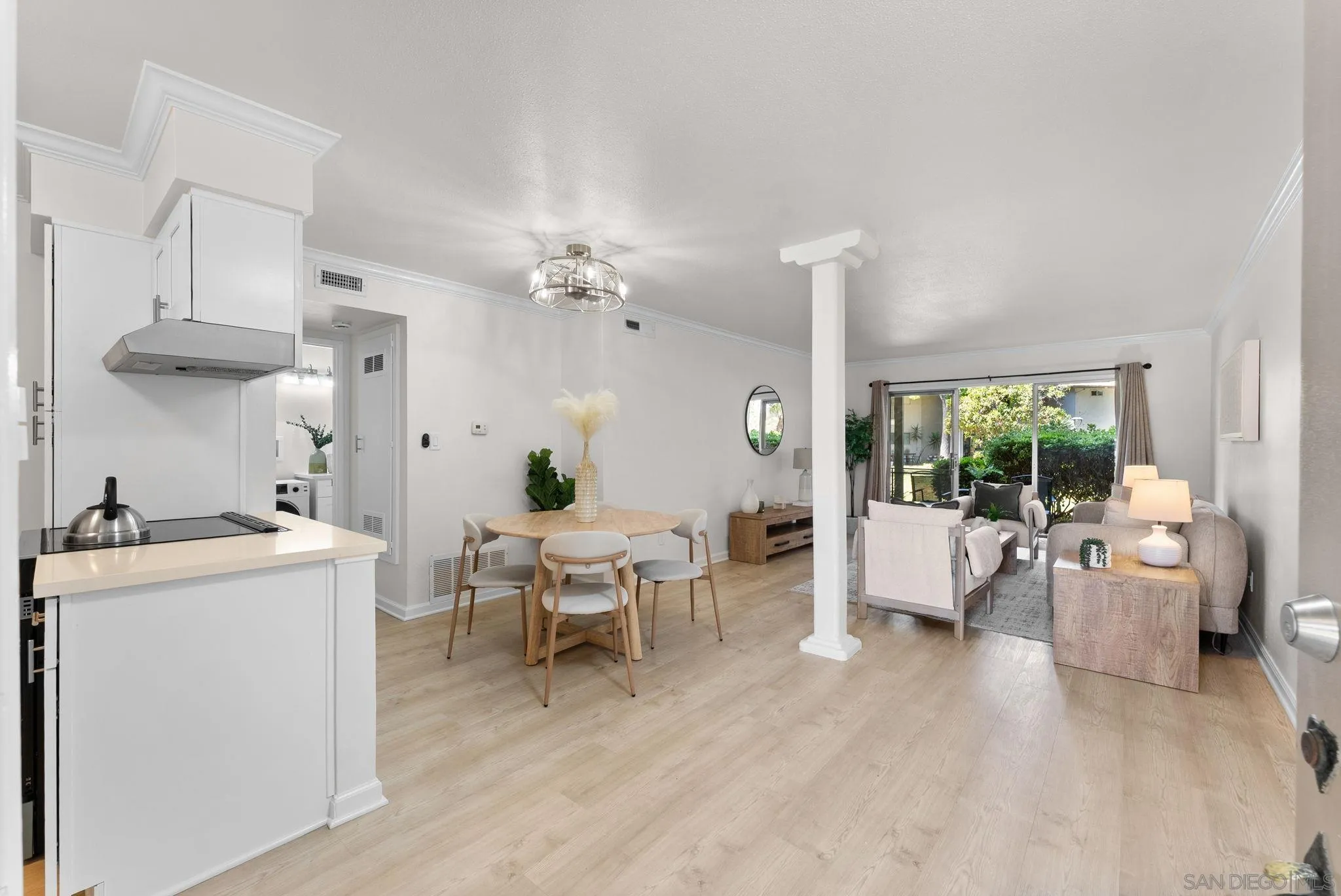 a living room with furniture and a dining table with garden view