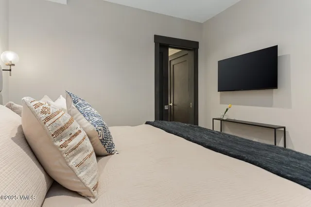 a bedroom with a bed and a flat screen tv