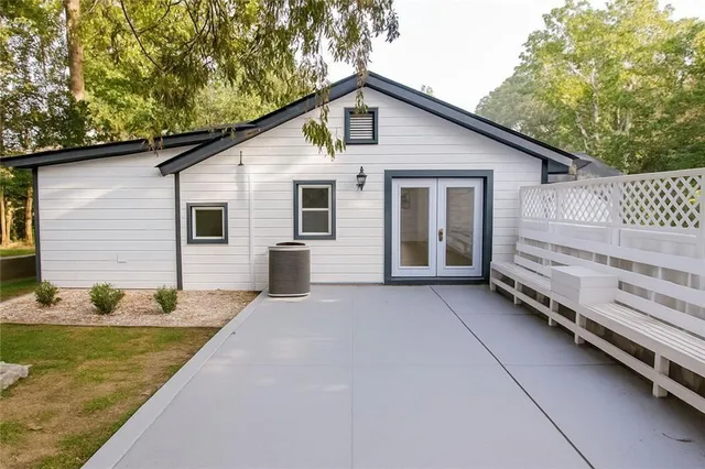 a view of a house with a big yard and large trees