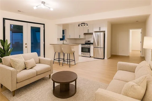 a living room with furniture and a view of kitchen