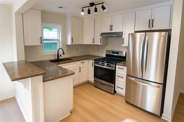 a kitchen with granite countertop a refrigerator stove and sink