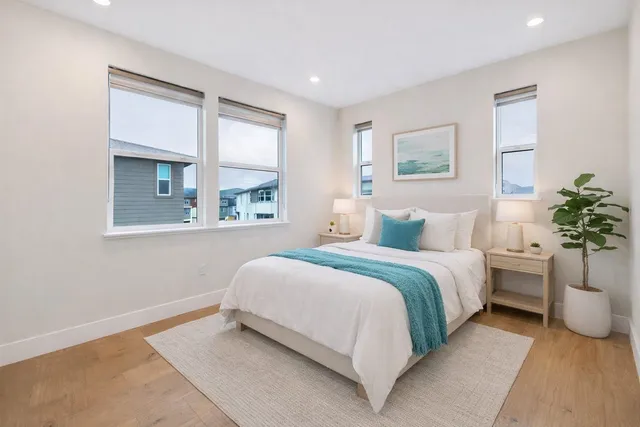 a bedroom with a large bed and a potted plant