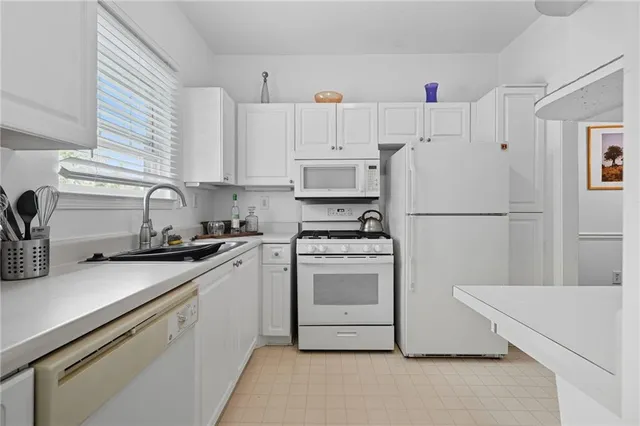 a kitchen with appliances a sink and cabinets