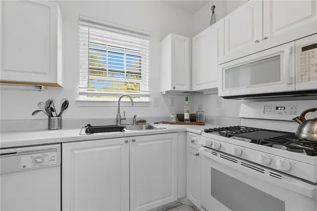 a kitchen with cabinets appliances a sink and a window